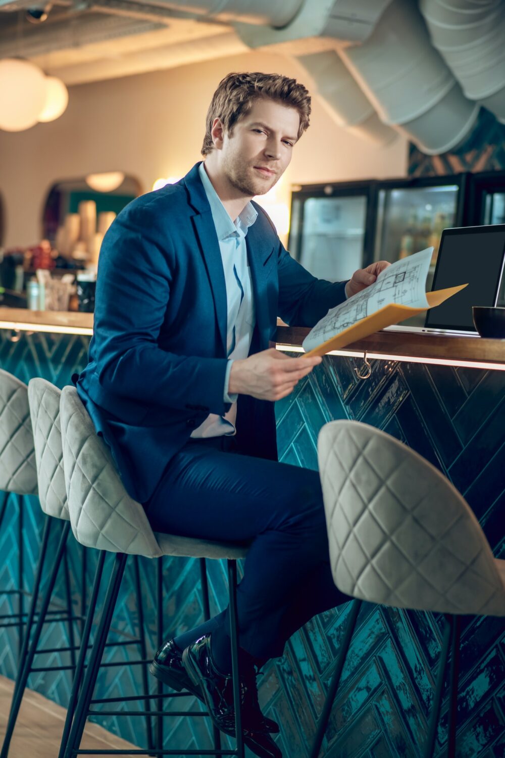 Man in business suit with document in cafe